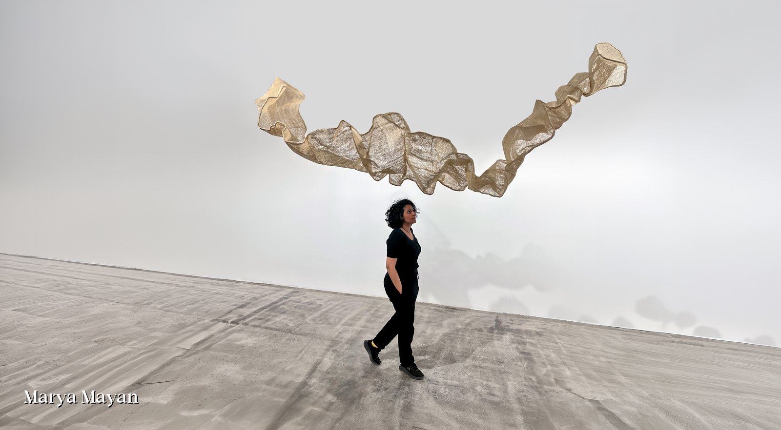 Marya Mayan beneath the suspended loofah installation Fragile